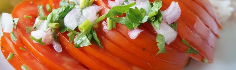 Germaine's tomato salad: thinly sliced tomato, dressed in vinegar and garnished with shallots, chives, and parsley