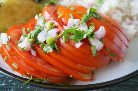 Germaine's tomato salad: thinly sliced tomato, dressed in vinegar and garnished with shallots, chives, and parsley