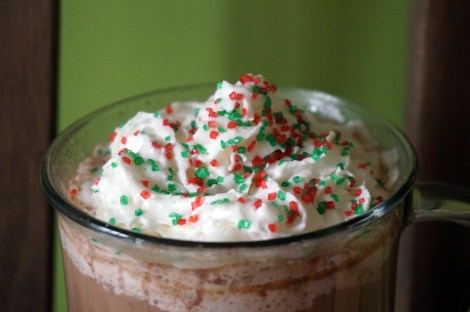 Pick-me-up peppermint mocha, a closeup on the mound of whipped cream with green and red sprinkles