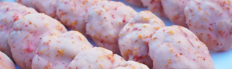 Rows of pale pink pussyhat cookies (blood orange glazed sugar cookies) line up on a white platter, specks of red and orange zest adorning each one.